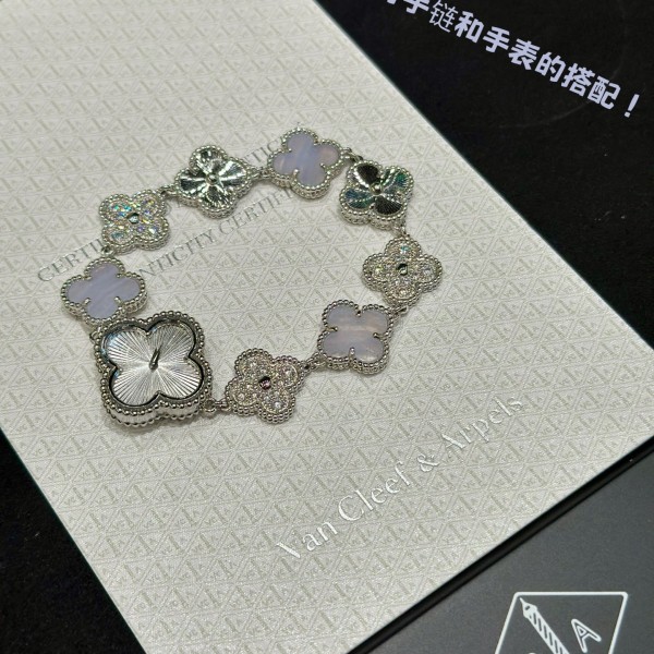 Van Cleef & Arpels watch with silver dial, diamond-set clover motif, and white mother-of-pearl.